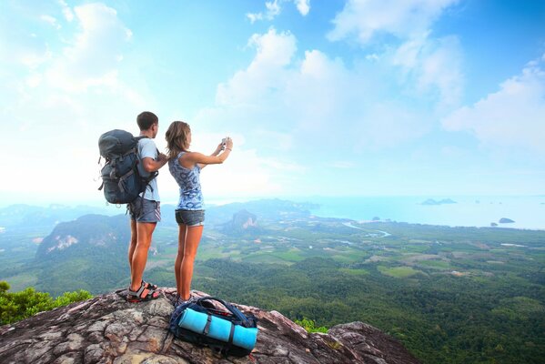 Ragazza con ragazzo con zaini in viaggio in montagna