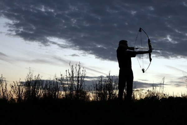 At sunset, a man was shooting an arrow