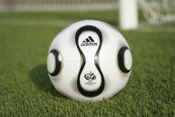 Piłka nożna na boisku z logo adidas
