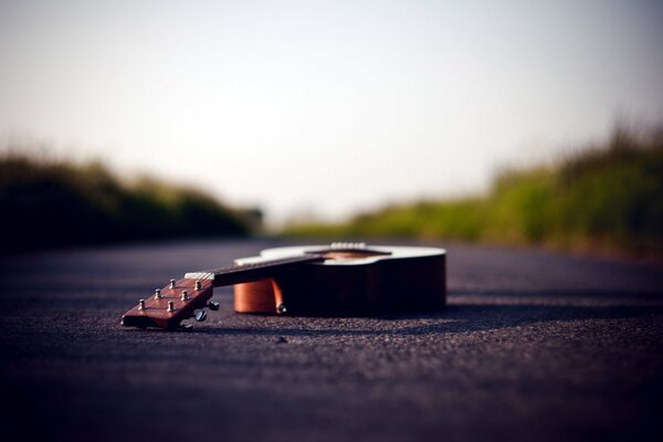 An abandoned guitar lying on the road