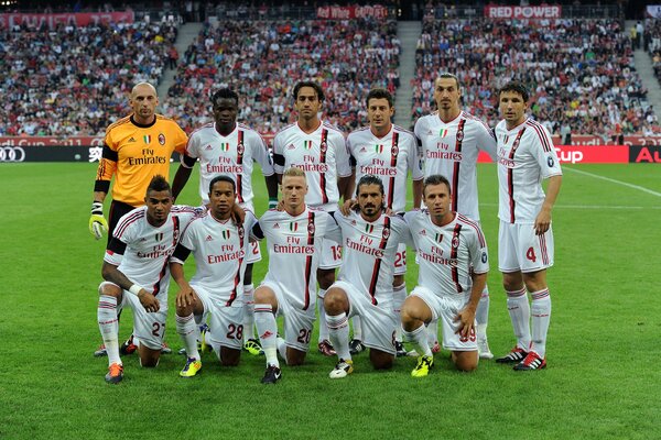 A team of football players at the stadium poses for a photo