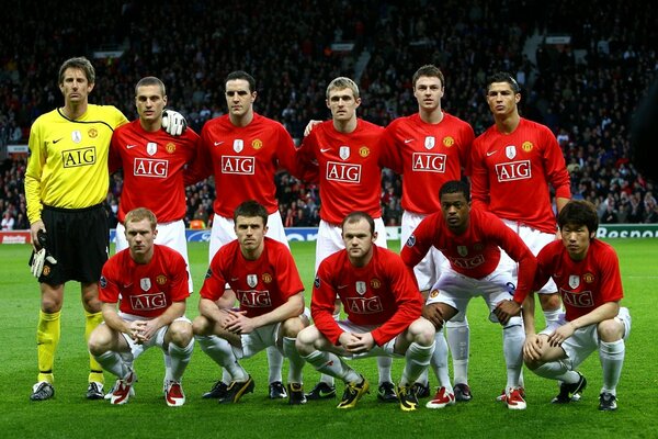 Sur le terrain de football, les footballeurs en maillots rouges posent pour la photo