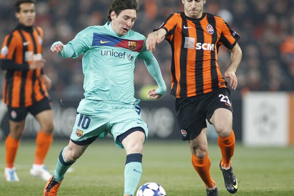 Futbolistas corriendo por el campo, luchando por la pelota