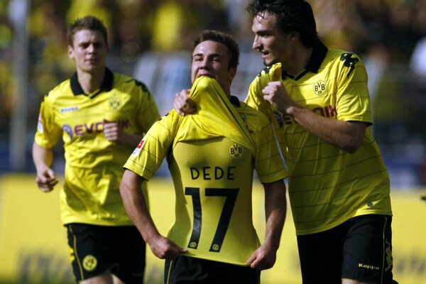 Futbolistas con uniforme amarillo se alegran de la victoria