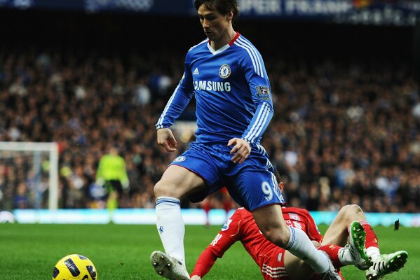 Fußballspieler Torres rollt den Ball über das Feld