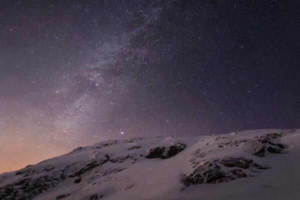 Foto des Sternenhimmels und der schneebedeckten Berge