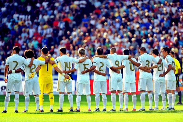 Real Madrid team listens to the anthem before a football match