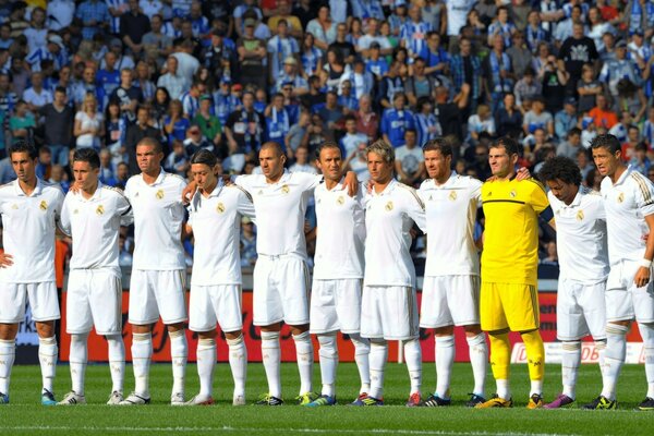 La squadra del Real Madrid fotografata sul campo con i tifosi sullo sfondo