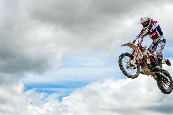 Un homme sur une moto fait un saut