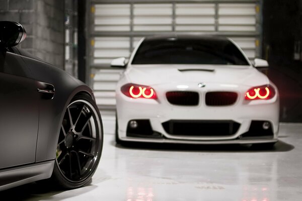 BMW blanche dans le garage pour le rôle de volets