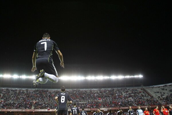 Futbolista en un salto sobre el estadio