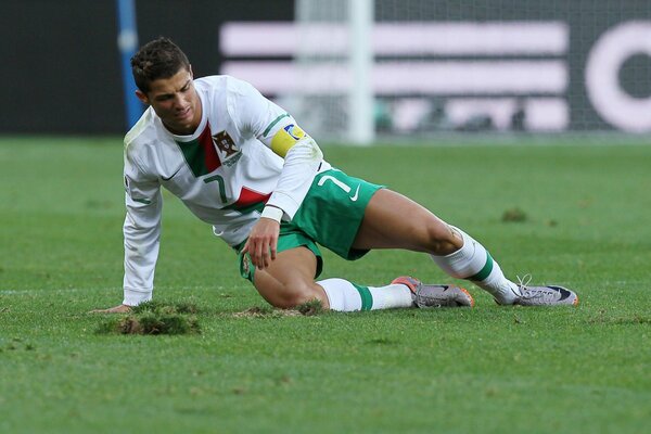 Il calciatore Ronaldo giace sul campo nell erba verde