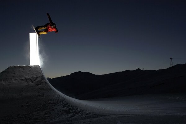 Salto de esquí de snowboard en una noche tranquila de invierno