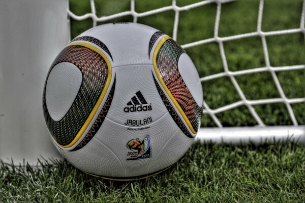 Футбольный мяч лежит в траве у ворот