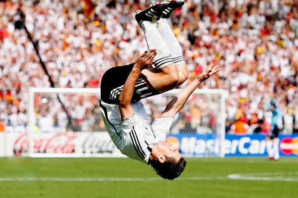 El futbolista de la selección alemana Miroslav Klose realiza un salto mortal al público tras el partido de la Copa del Mundo