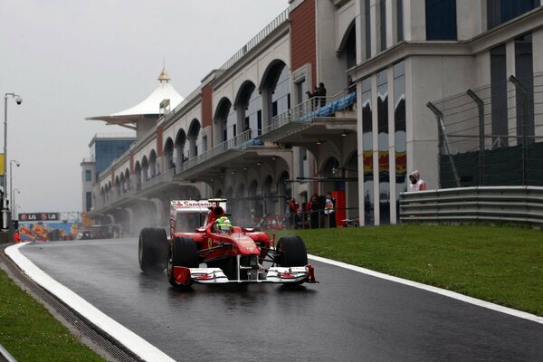 Ferrari races on a wet road in Formula 1