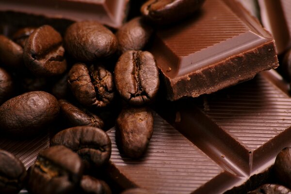 Trozos de chocolate en barra con granos y café