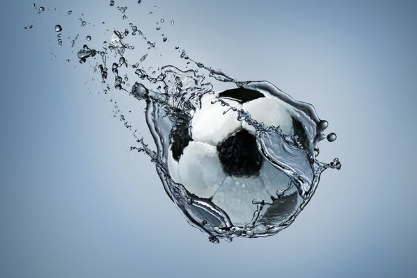 Un ballon de football à partir duquel l eau s écoule est suspendu dans l air
