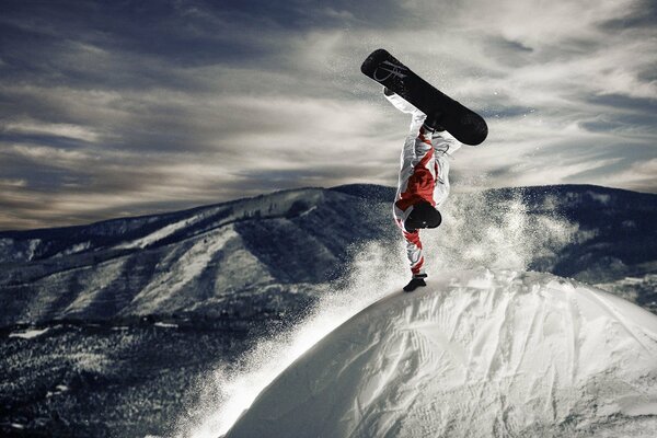 A snowboarder s trick on a snowy peak