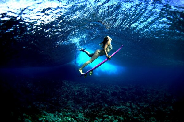 Ragazza surfista nel profondo del mare blu