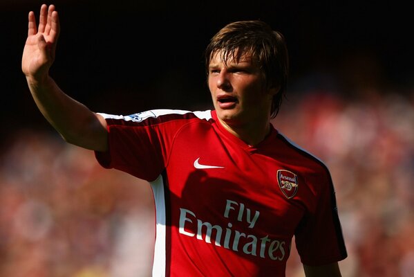 Arshavin in a red T-shirt waves his hand