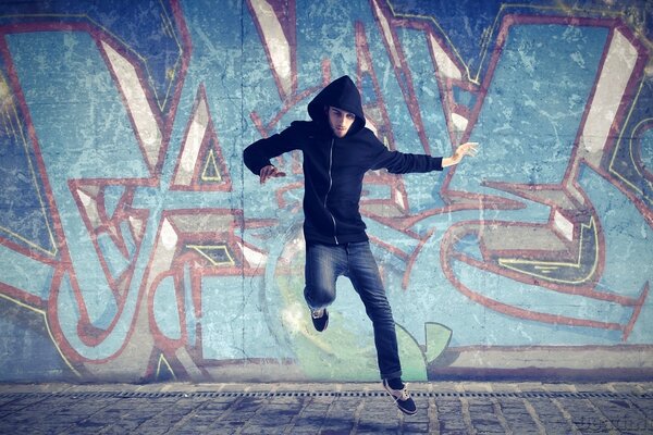 Прыжок человека на фоне граффити
