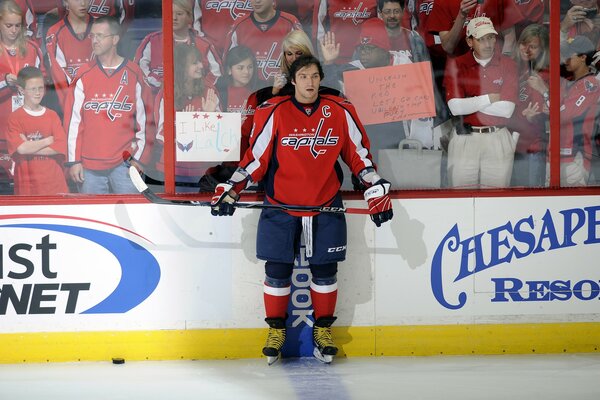 Joueur de hockey en uniforme rouge avec un bâton dans les mains