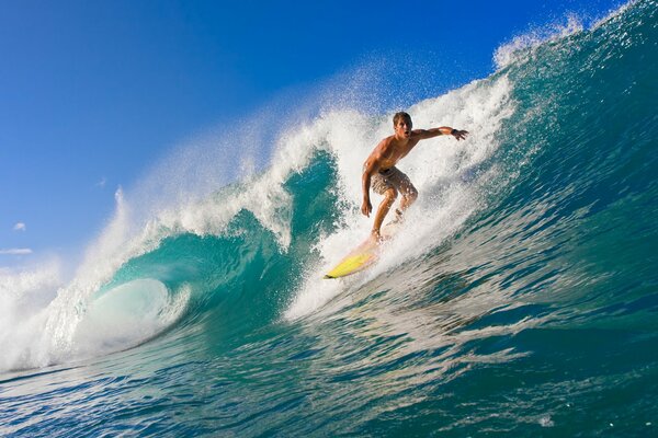 Garçon surfeur sur les vagues bleues