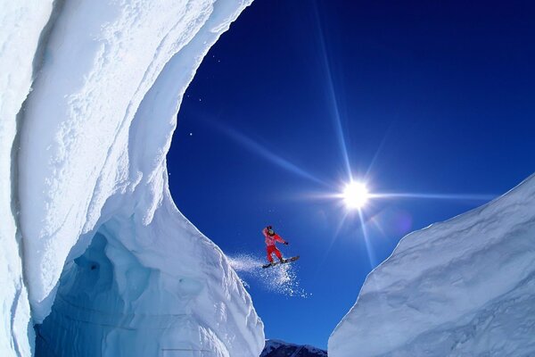 A snowboarder s flight between snowy mountains