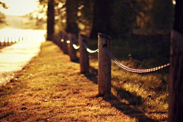 Massive fence along the alley wooden poles in chains