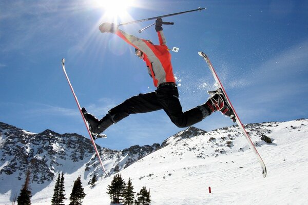 Skifahrer springen im Hintergrund der Berge