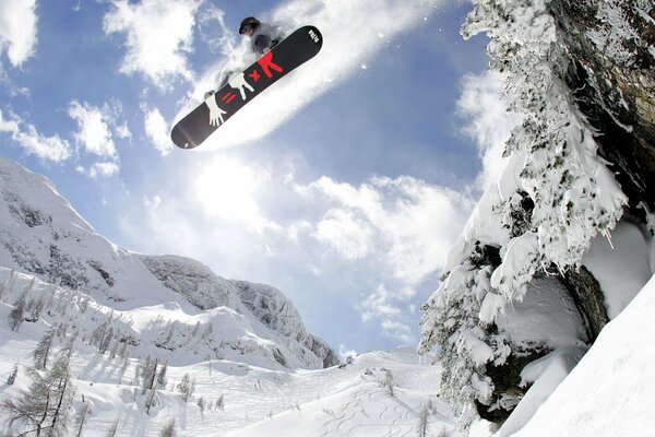 Snowboarder jumping on the background of snowy mountains