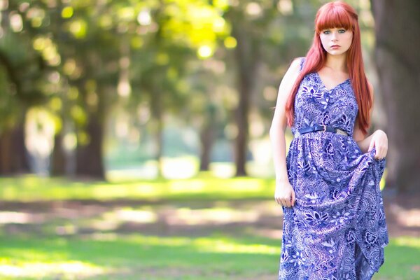 Ragazza dai Capelli rossi in abito viola nel parco