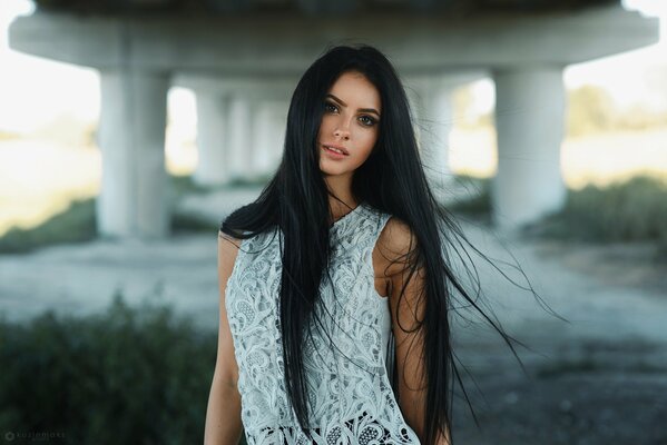 Morena chica con el pelo largo bajo el puente