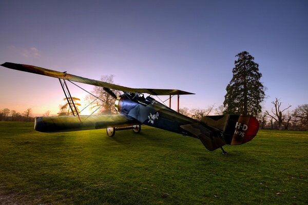 Samolot na zielonym trawniku w promieniach słońca