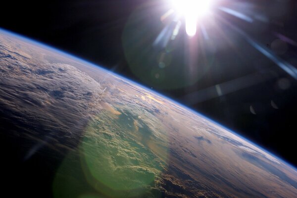 The rays of the sun above the earth a view from space