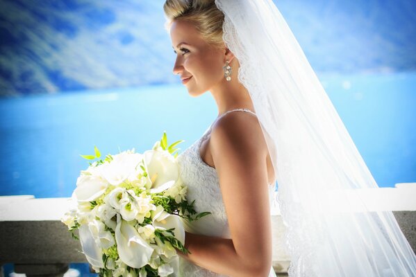 La novia en un vestido blanco con un ramo