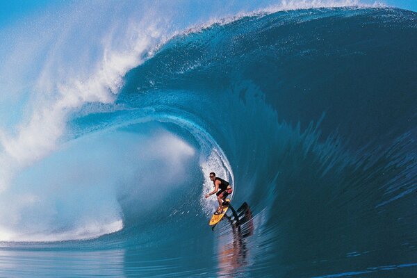 Surfeur dans la vague bleue de l océan