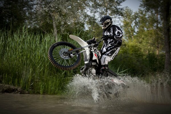 Water splashes from under the wheels of a motorcycle bike