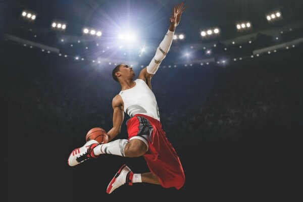 A man in a red and white sports uniform with a basketball