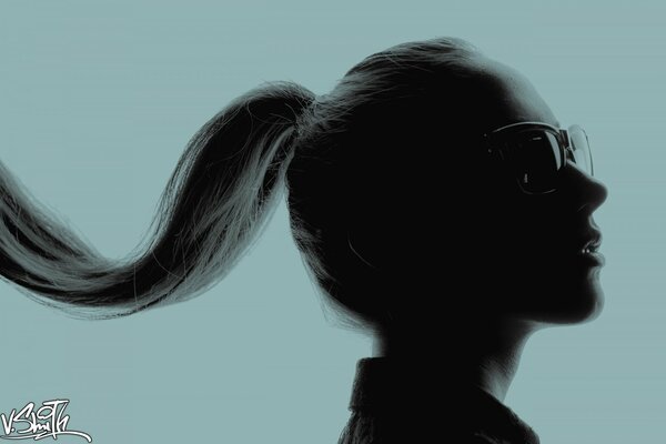 La cara de una chica con gafas con el pelo largo en una cola de caballo