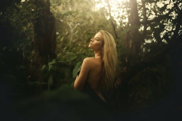 Hermosa chica en el bosque desde atrás