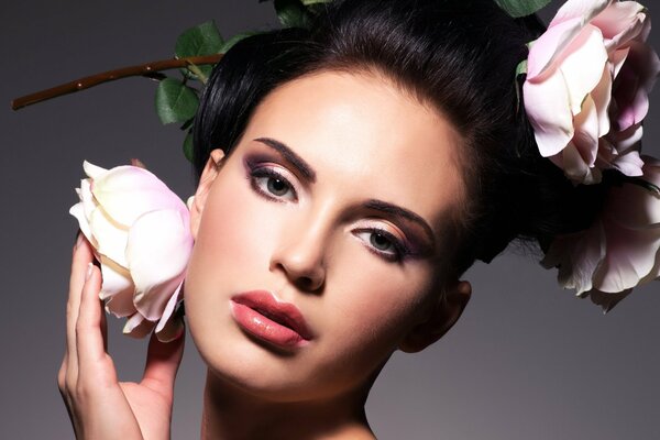 Photo du visage d une fille avec du maquillage du soir et des roses