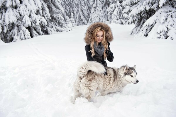 Blondine mit Hund im Winterwald