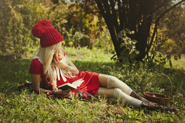Dziewczyna W Czerwonym Kapturku zjada jabłko w lesie