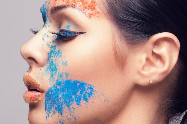 A girl with false eyelashes and colorful makeup