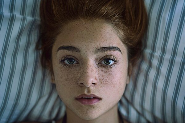 Rousse fille avec des taches de rousseur et des yeux verts