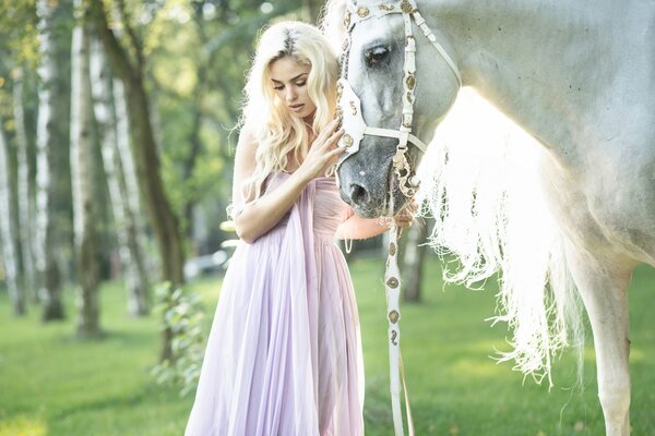 Mädchen in der Nähe des Pferdes im Kleid