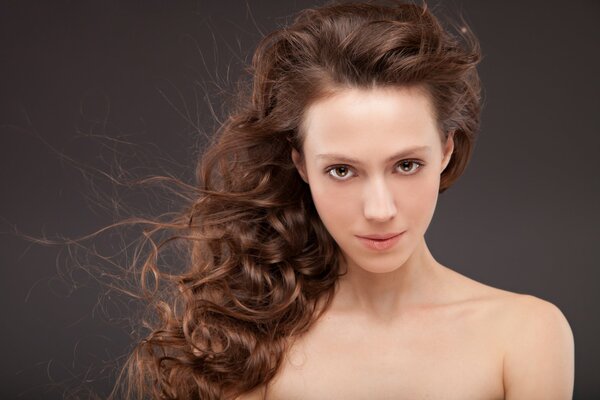 Regard des yeux bruns d une fille aux cheveux ondulés