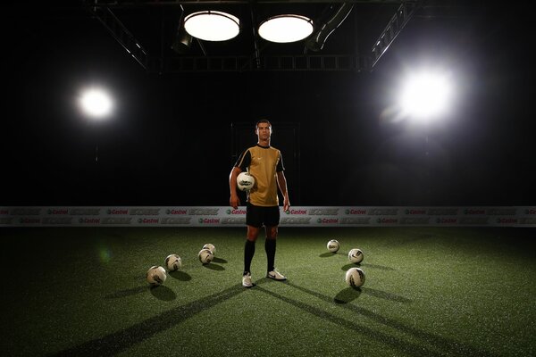 Cristiano Ronaldo con balones en el campo de fútbol a la luz de los focos